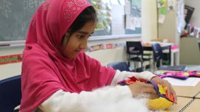 Une élève rembourre de coton sa création textile. Crédit @ Valentina Plata.