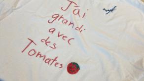 Un chandail blanc est décoré des mots « j'ai grandi avec des tomates ». Crédit photo @ Yves Amyot.