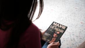 Marie-Christine tient un magazine dont elle a fait la couverture, avec le titre « Ma vie dans le noi r»»