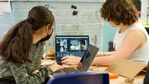 Deux élèves font du travail de montage sur un ordinateur portable.